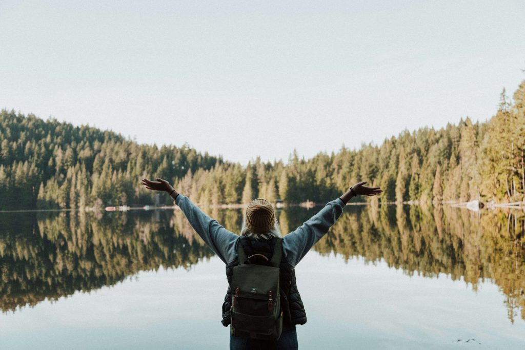 lake | emdr therapy in englewood, co | emdr therapy in littleton, co | emdr therapy in greenwood village, co | emdr colorado | emdr therapy in denver | emdr trauma therapy | 80125 | 80121 | 80110 Image of a woman wearing a backpack standing in front of a lake with her arms in the air. If you struggle with anxiety, depression, trauma, and more, learn how EMDR therapy in Littleton, CO can help you.