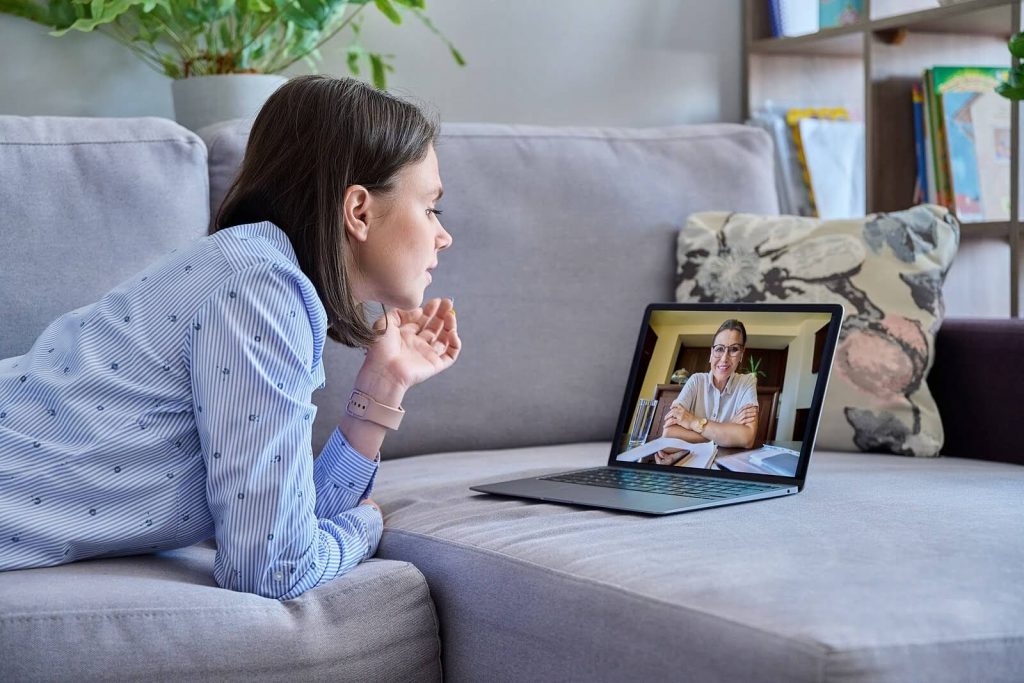 telehealth | telehealth in denver, co | telehealth therapy in englewood, co | telehealth in littleton, co | online therapists | online therapy | 80125 | 80121 | 80110 Image of a woman laying on a couch, speaking to a online therapist on a laptop. Begin overcoming your anxiety, depression, and more with the help of telehealth in Denver, CO.
