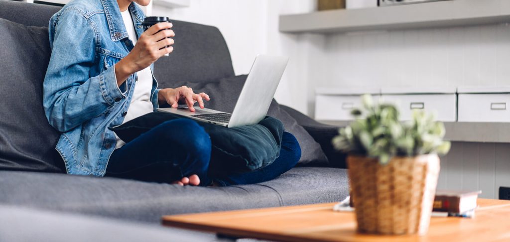 woman on couch | telehealth in denver, co | telehealth therapy in englewood, co | telehealth in littleton, co | online therapists | online therapy | 80126 | 80129 | 80130 Image of a woman sitting on a couch holding a cup and laptop. Begin telehealth in Denver, CO to overcome your anxiety and more in convenient ways.