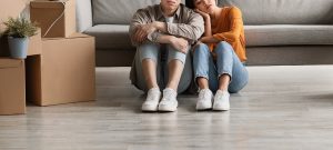 anxiety therapist in englewood, co | social anxiety treatment in englewood, co | anxiety therapy in greenwood village, co | 80126 | 80129 | 80130 A couple sit on the ground next to one another against their couch with stressed expressions. The moving boxes to the left could symbolize the stress of a move that an anxiety therapist in Englewood, CO can help you cope with. Learn more about social anxiety treatment in Englewood, Co and how anxiety therapy in Greenwood Village, CO can help.