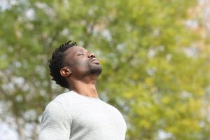 deep breath | trauma therapist in englewood, co | emdr therapy in denver, co | neurofeedback therapy in littleton, co | 80125 | 80121 | 80110 A man with his eyes closed, taking a deep breath in a green, natural setting, representing calmness. Learn how a trauma therapist in Englewood, CO can offer support by searching for EMDR therapy in Denver, CO and beyond. They can offer child therapy in Englewood, CO and other services.
